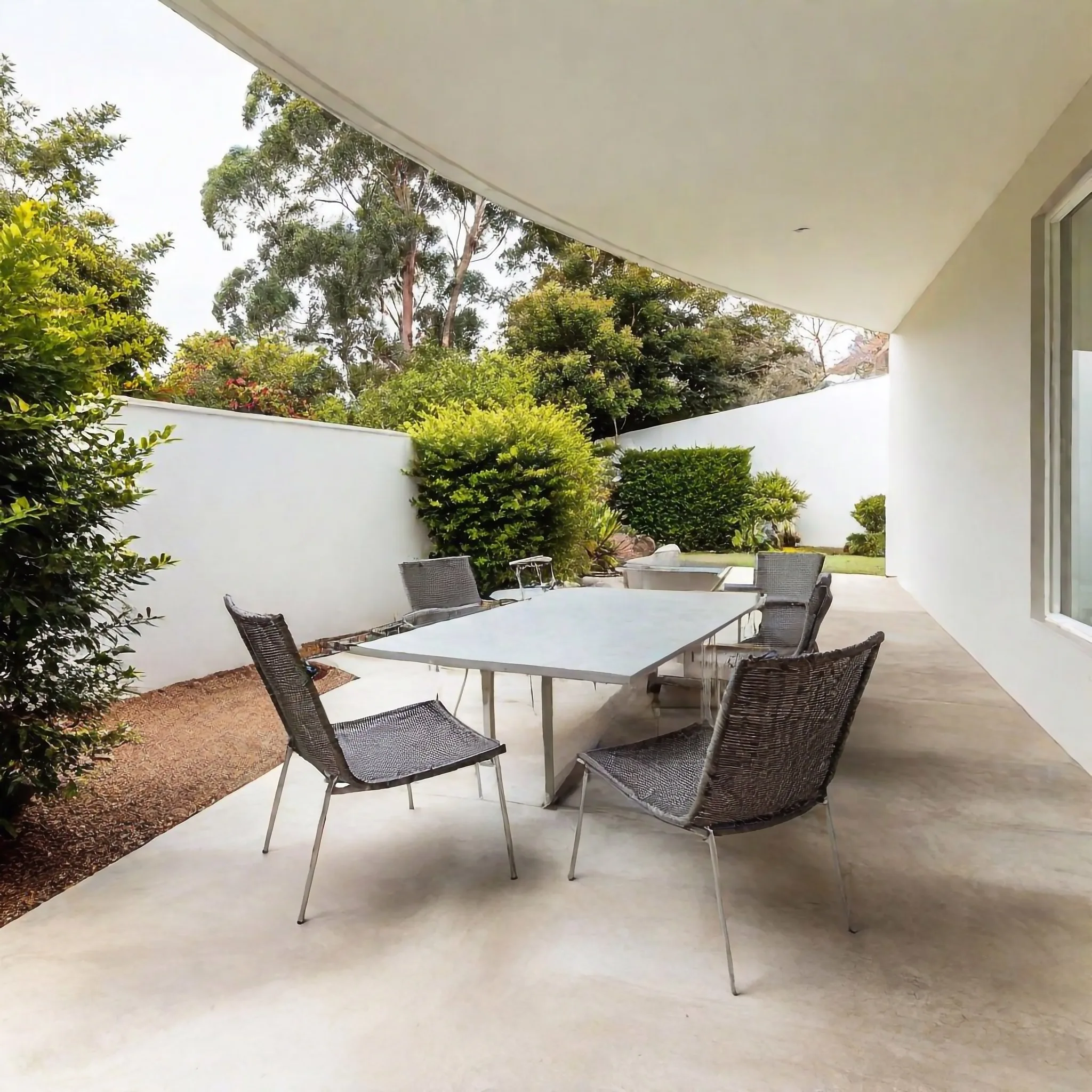 Concrete courtyard patio with an outdoor dining table