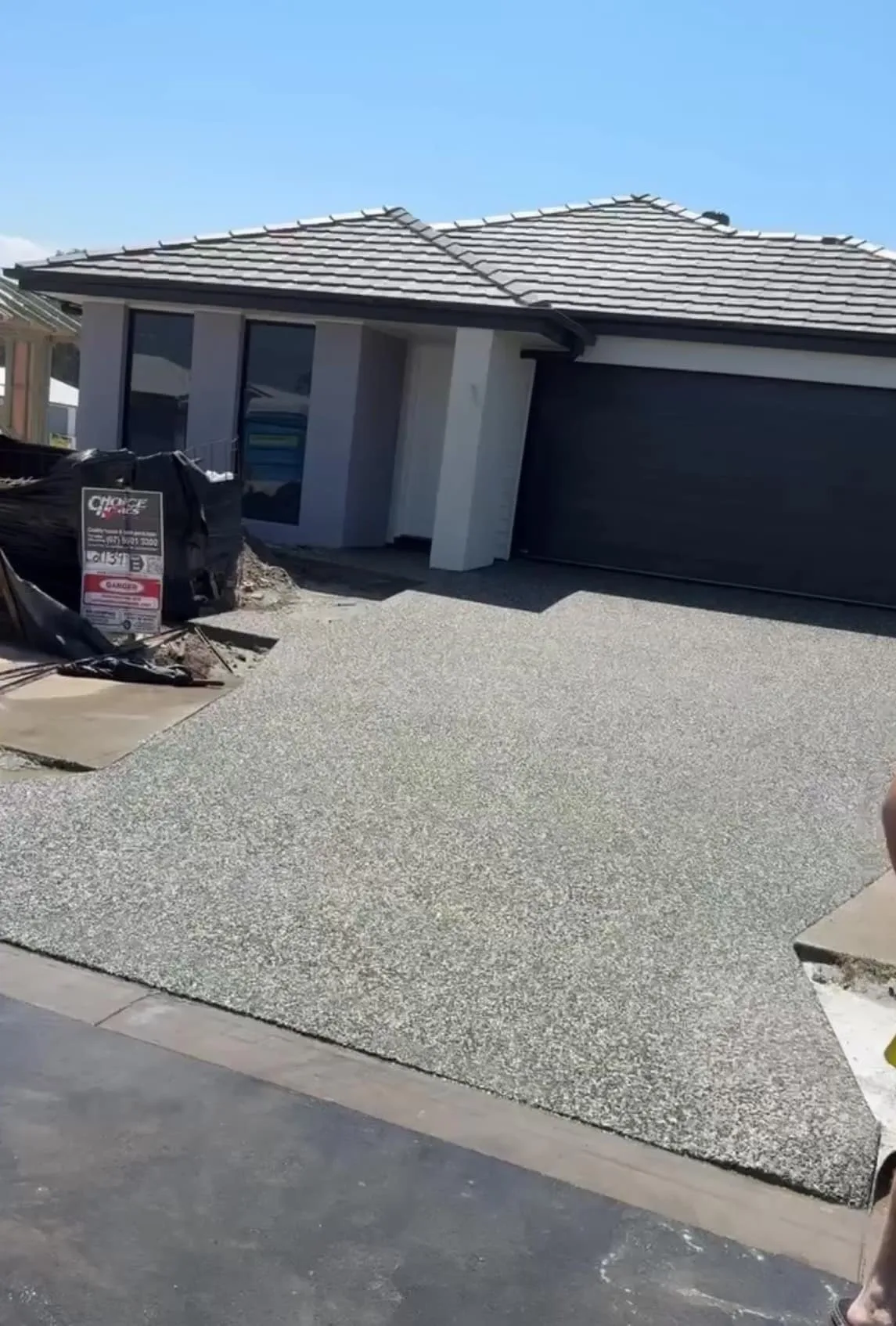 Exposed aggregate crossover and driveway in front of a modern home