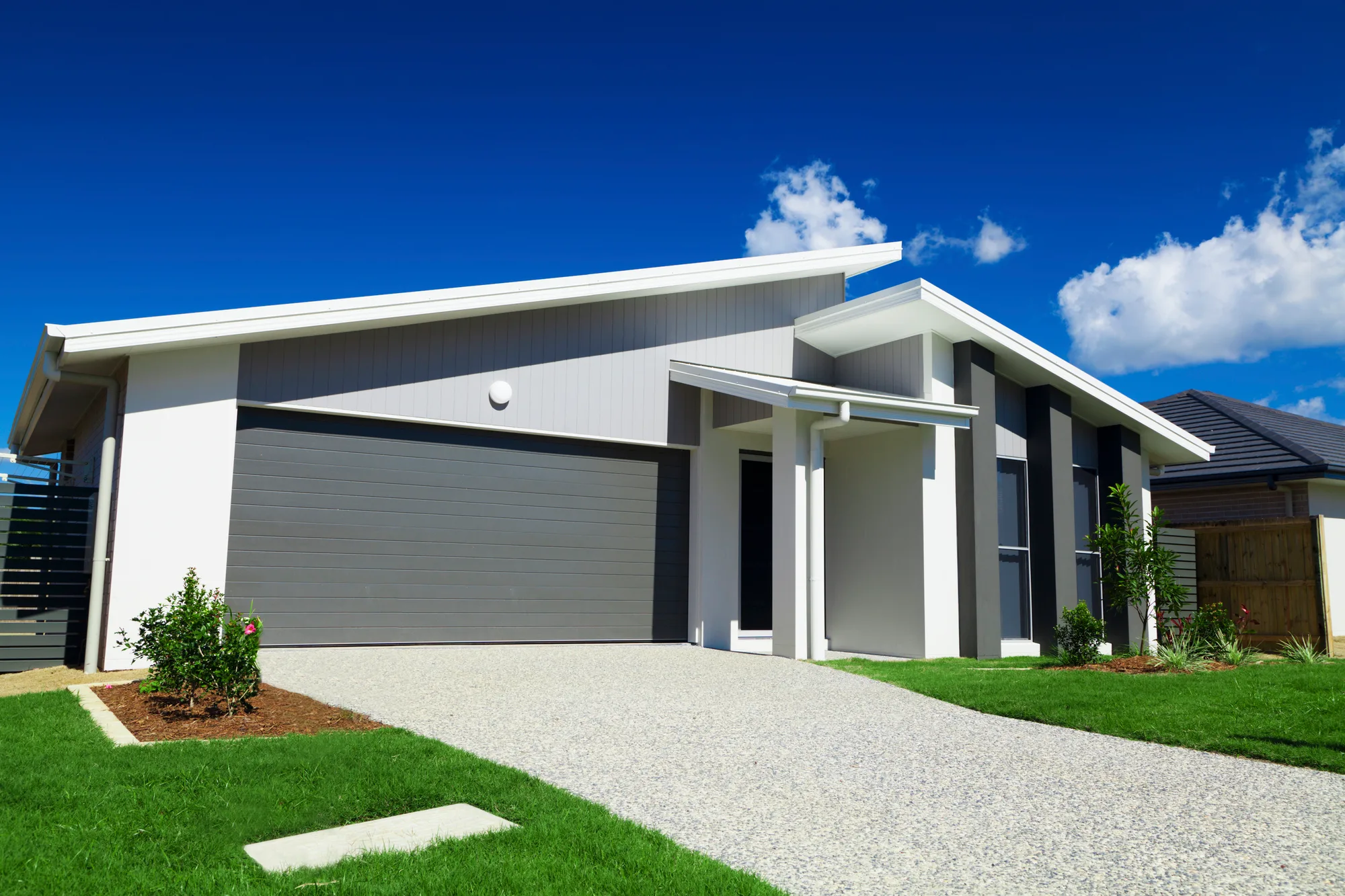 Exposed aggregate driveway leading to a modern two-storey home